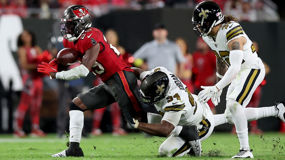 Rachaad White #29 of the Tampa Bay Buccaneers fumbles the ball against Cameron Jordan #94 of the New Orleans Saints during the third quarter in the game at Raymond James Stadium on December 05, 2022 in Tampa, Florida.