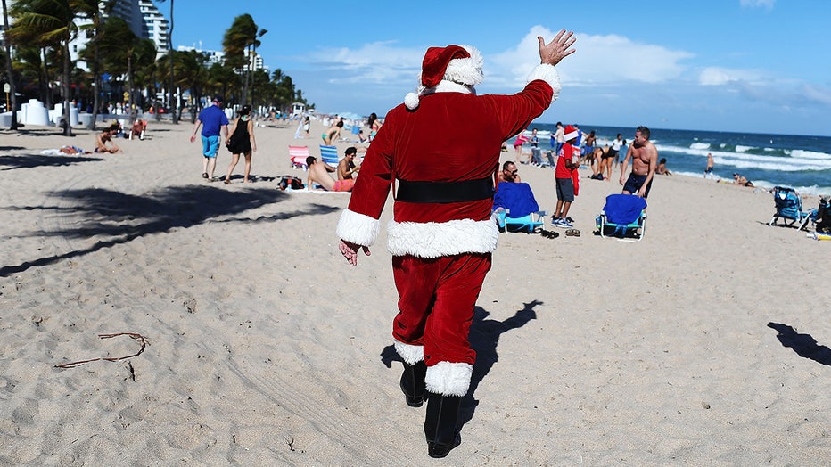 A man dressed as Santa Claus walks on Fort Lauderdale beach.