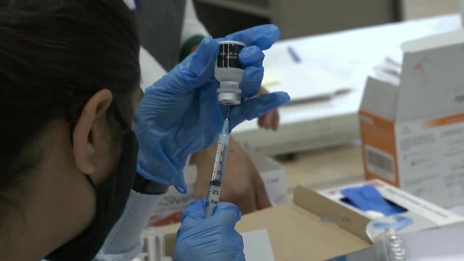 A healthcare worker prepares a COVID-19 vaccine. 