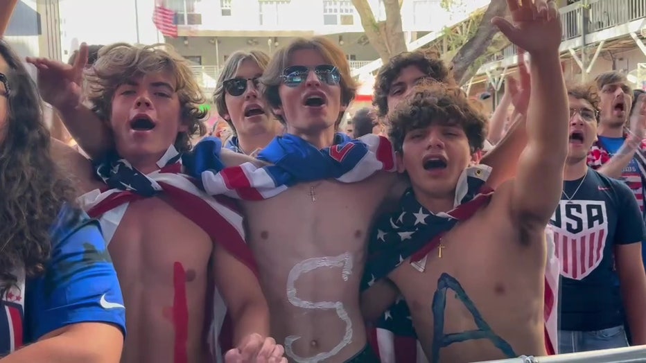 Three guys cheer on team USA during the World Cup. 
