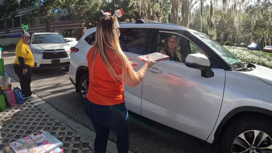 A volunteer hands a military family. 