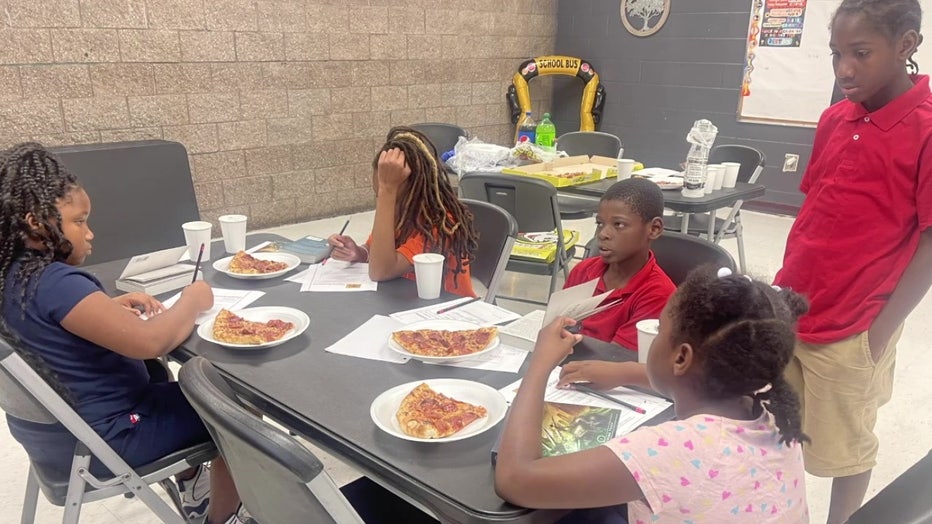 The children enjoy a pizza party after finishing a book. 