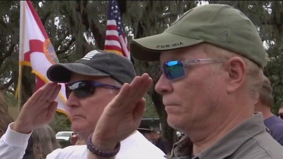 Men salute during a Wreaths Across America ceremony. 
