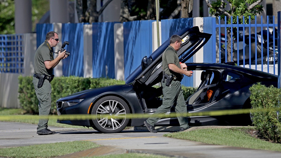 Crime scene investigators photograph the BMW where rapper XXXTentacion was shot to death outside of Riva Motorsports in Deerfield Beach, Florida on June 18, 2018.