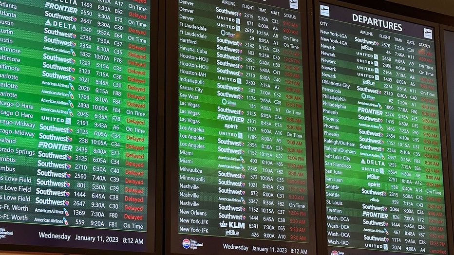 Arrival-departure monitors at Tampa International Airport after the FAA ordered all domestic flights to pause until 9 a.m.