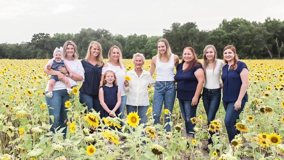 A family poses for a photo in a sunflower field at Three Son Farm. 