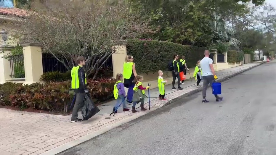 Volunteers clean up after the Gasparilla parade. 