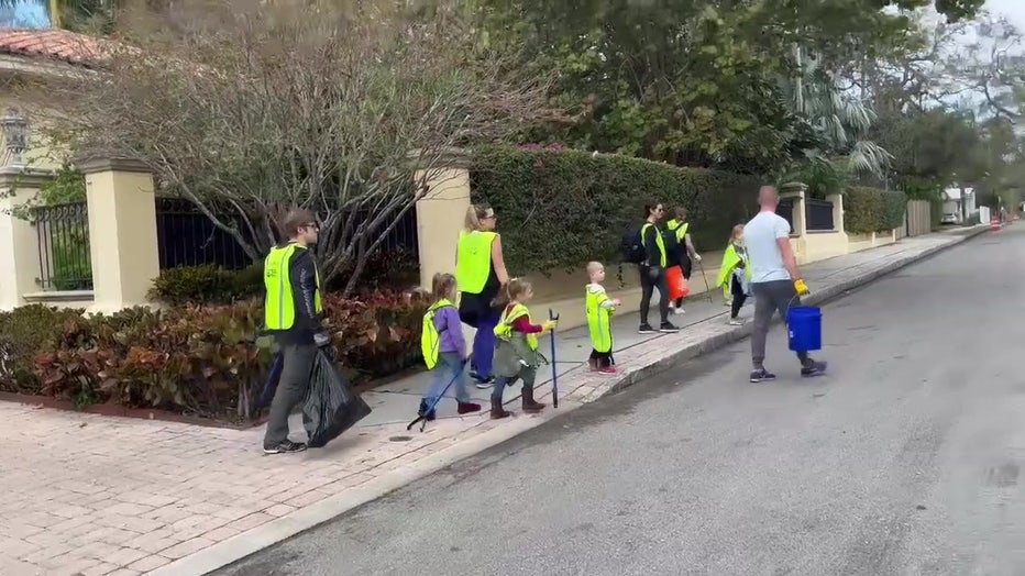 Volunteers clean up after the Gasparilla parade.