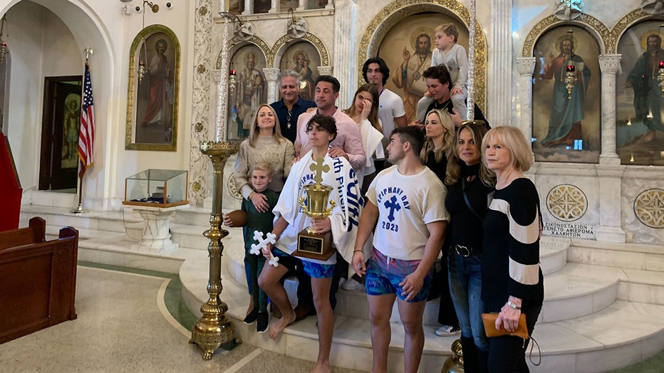 16-year-old George Stamas, who retrieved the wooden cross at the 117th annual Epiphany Celebration in Tarpon Springs, poses for a photo with his family.
