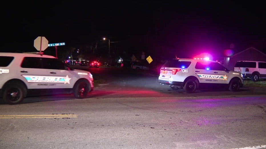 Patrol vehicles parked outside shooting scene.