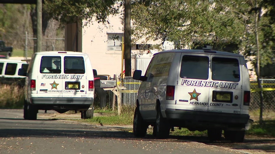 Forensic vans parked outside of area where high school student was shot and killed. 