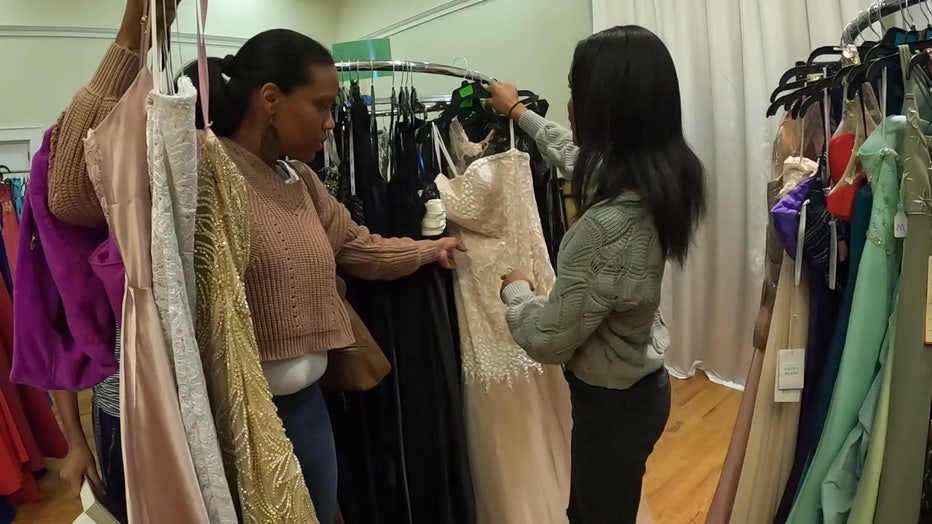 Woman helps teen pick out a formal dress at Gowns for Girls.