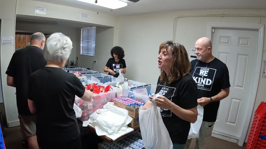Volunteers with the Kind Mouse pack meals for kids to take home on the weekend.