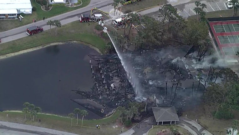 Aerial view of firefighters trying to put out fire at Venice mobile home community clubhouse.