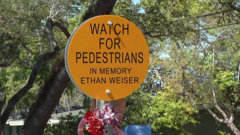 A sign asking drivers to watch for pedestrians in honor of Ethan Weiser. 