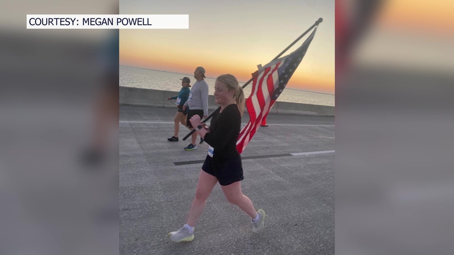A Skyway 10K participant runs with the American flag. 