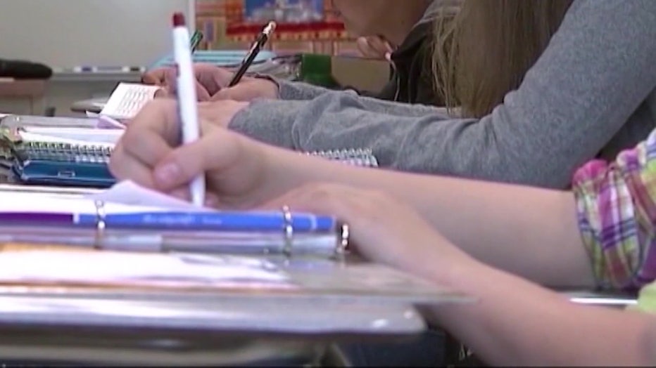 File: Students writing in notebooks. 