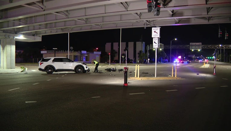 Investigators at the scene of a crash involving a police cruiser and a motorcyclist late Wednesday night.