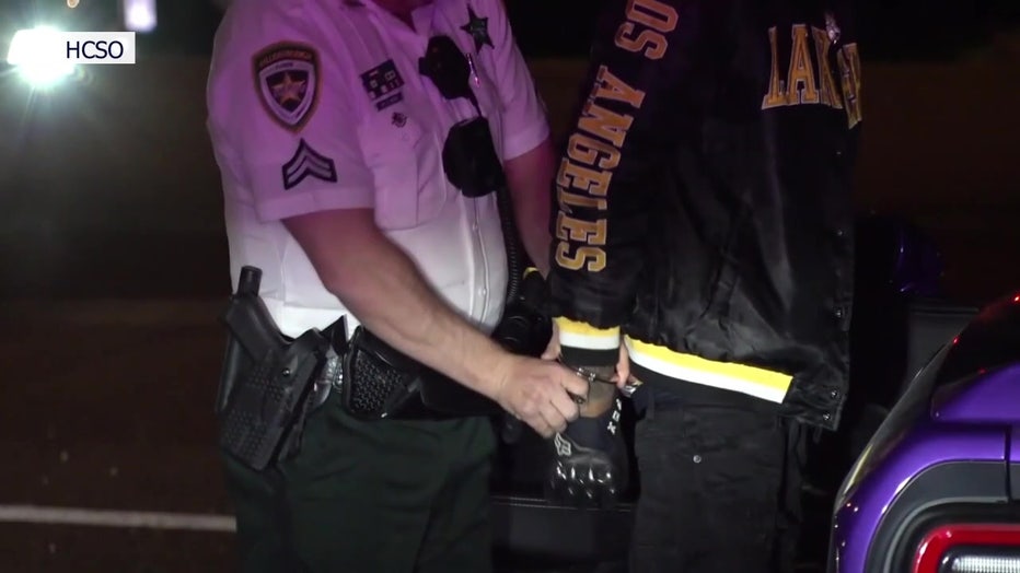 A deputy handcuffs an accused illegal street racer. 