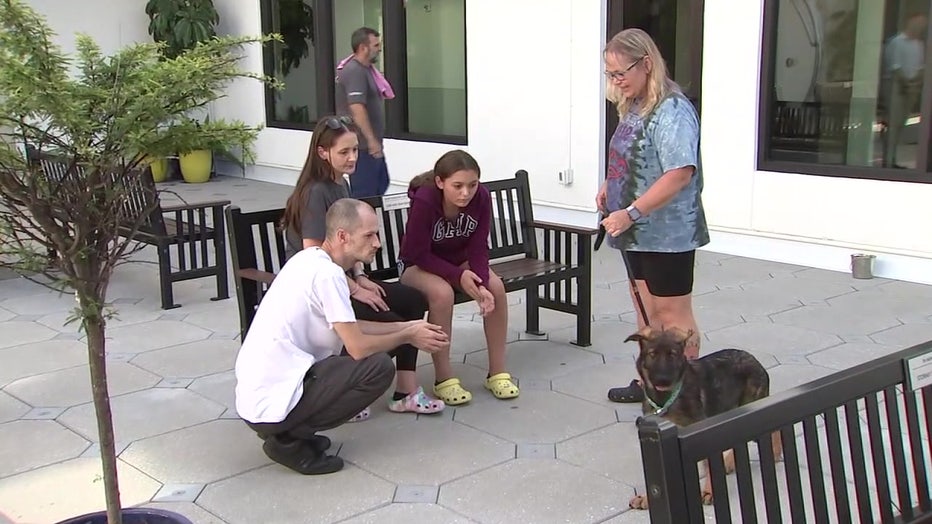 People playing with a dog. 