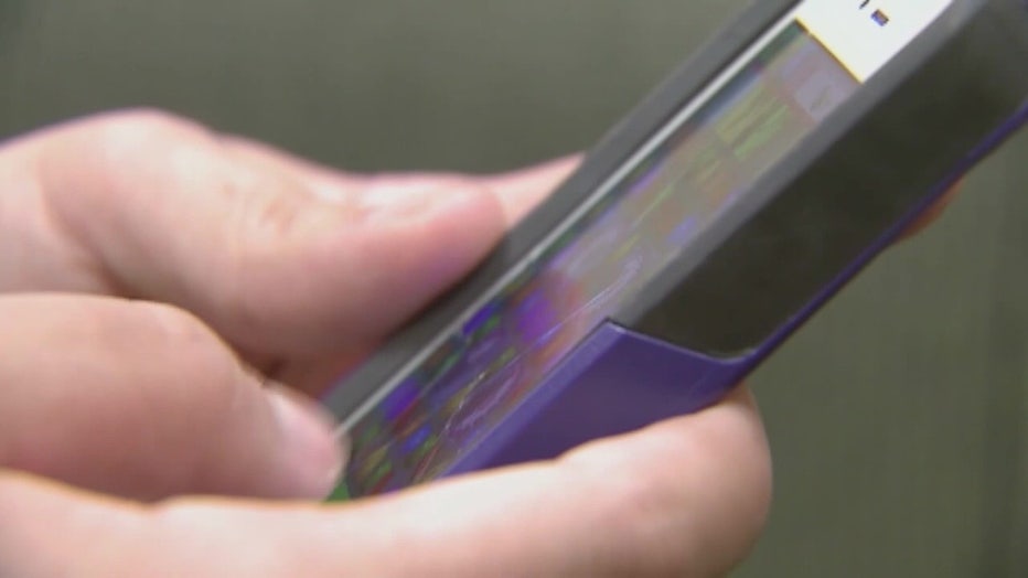 File: Hands on a cell phone.