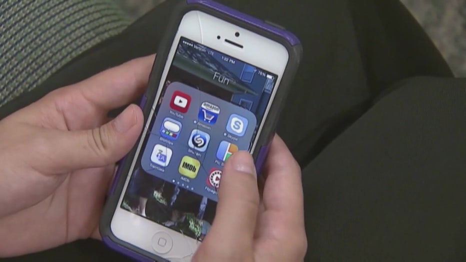 File: Hands on a cell phone.