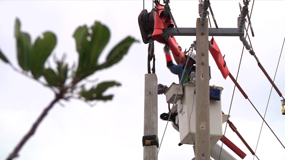 File of a man working on powerlines.