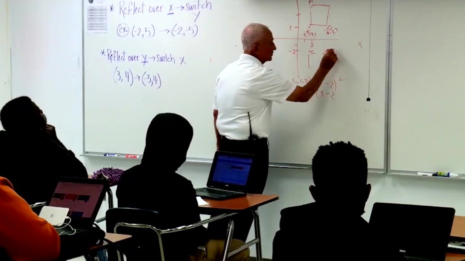 File: Teacher at a chalk board.