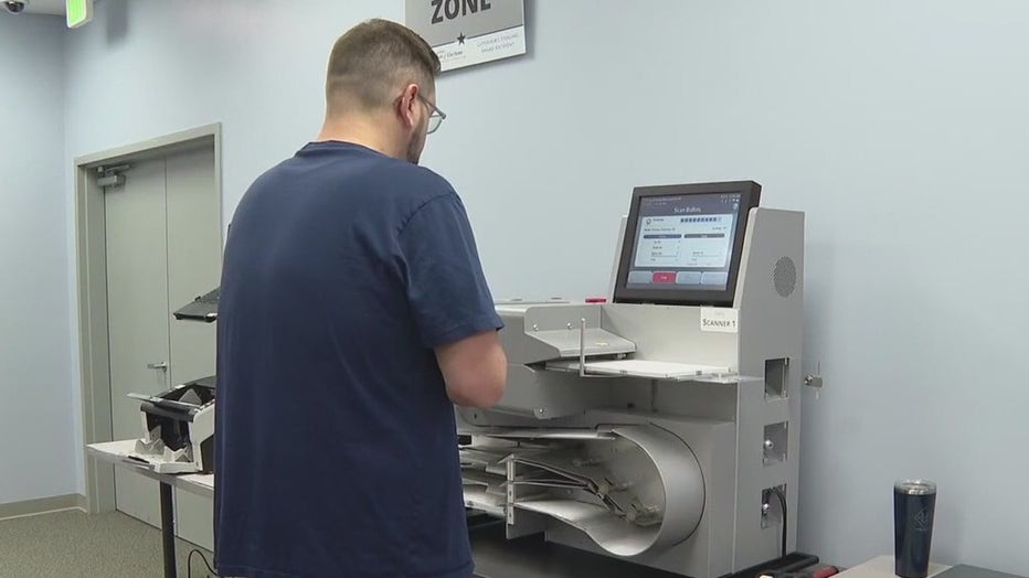 File: Election ballots going through machine.