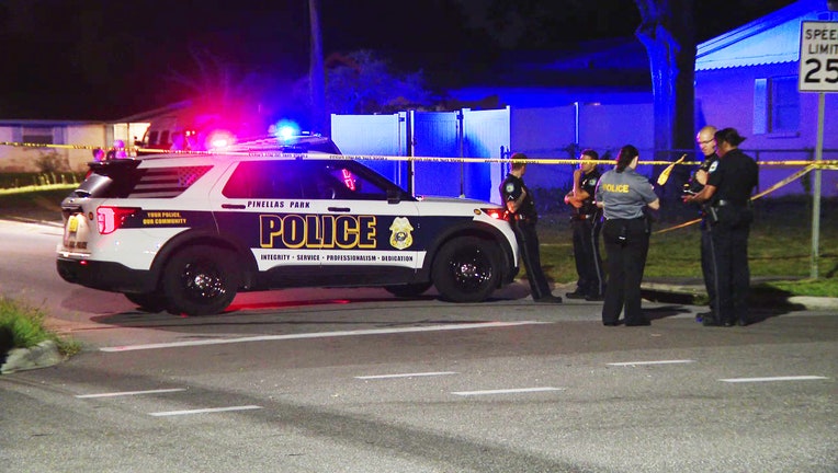 A police car and investigators outside deadly officer-involved shooting scene.