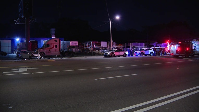 Police say a woman drove into the back of a TPD cruiser that was stopped at a crash scene early Tuesday morning.