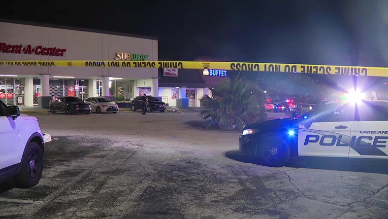 Police cars and crime scene tape in a parking lot where one person was shot early Thursday morning. 