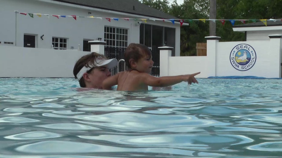 An instructor and a child in the pool. 