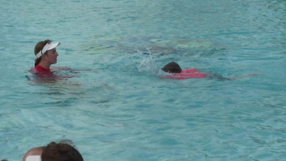 A child learns to swim in the pool. 