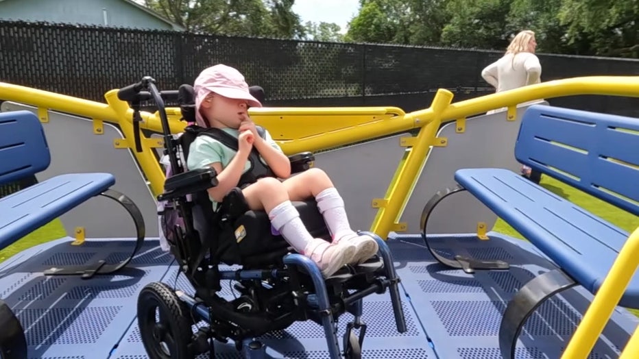 Girl in wheelchair enjoy the new playground. 