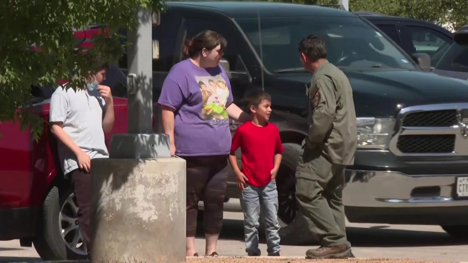 A mother and a child outside a mass shooting scene.