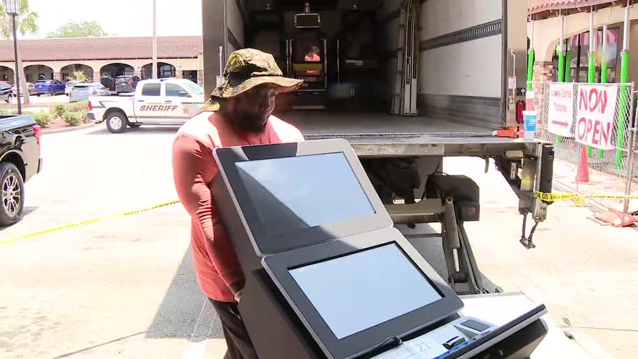 A man hauling away a slot machine that was allegedly used for illegal gambling. 