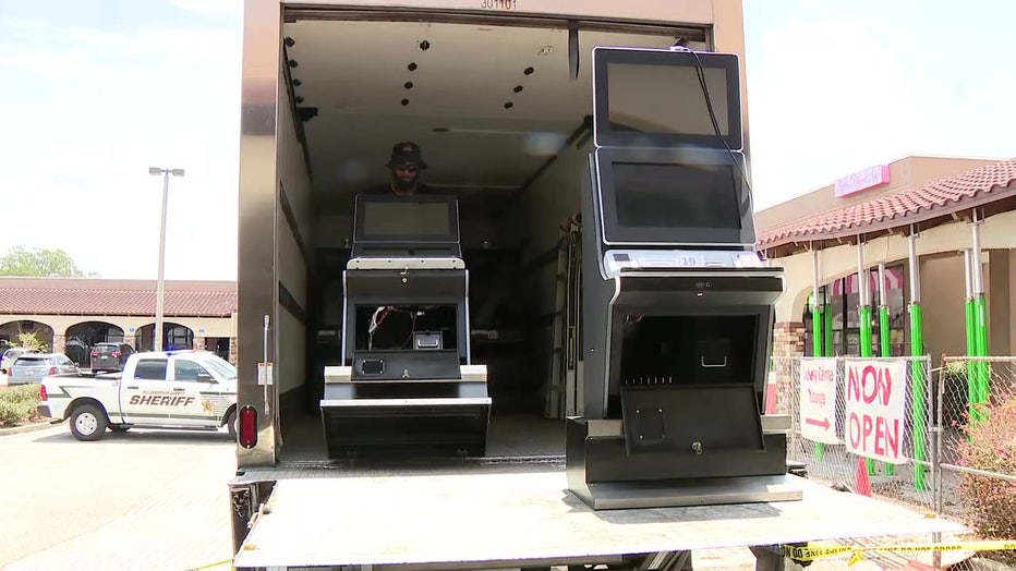 Slot machines being seized and loaded onto truck. 