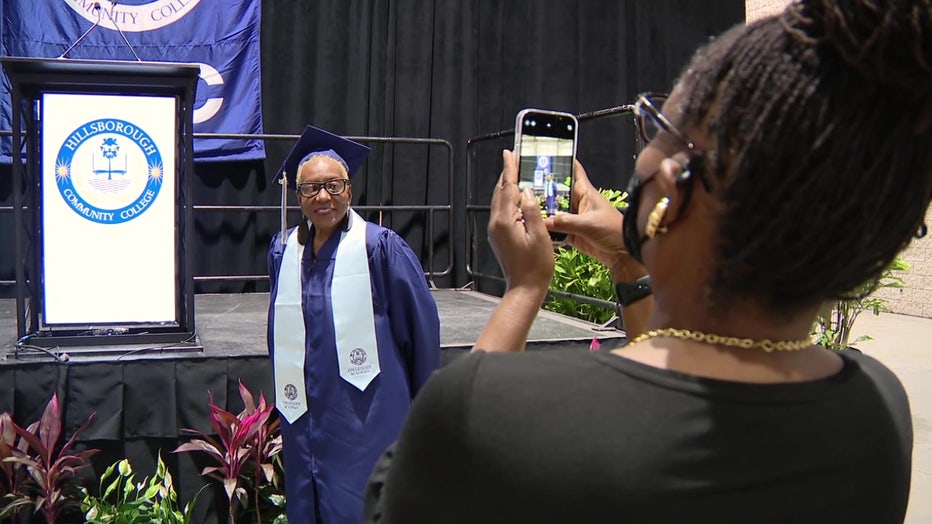 Richardene Caso's daughter snaps a photo of her in her cap and gown.