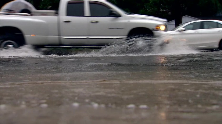 A truck drives through water. 