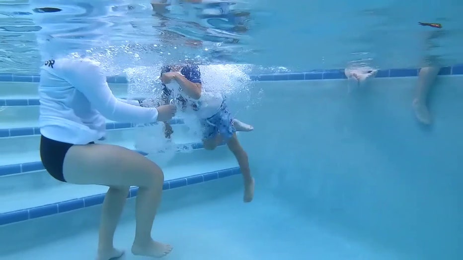 A swim instructor teaches a child in the pool. 