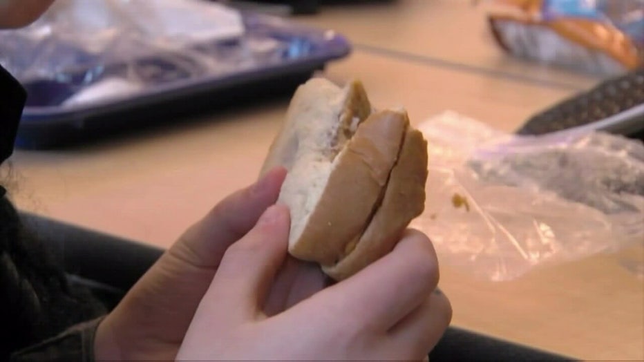 A child holds a sandwich. 
