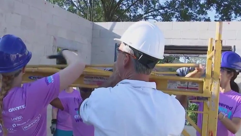 Women are helping construct a home for a single mother. 