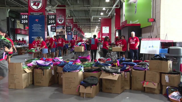 Volunteers stuff 30,000 backpacks in preparation for Titus O'Neil's annual Back to School Bash
