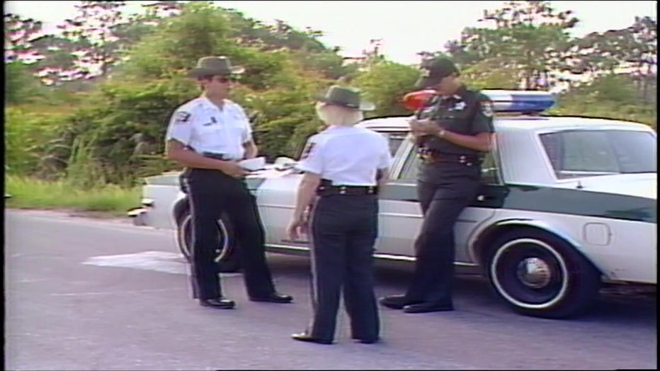 Law enforcement stand at the scene where Wood's body was discovered in 1984. 