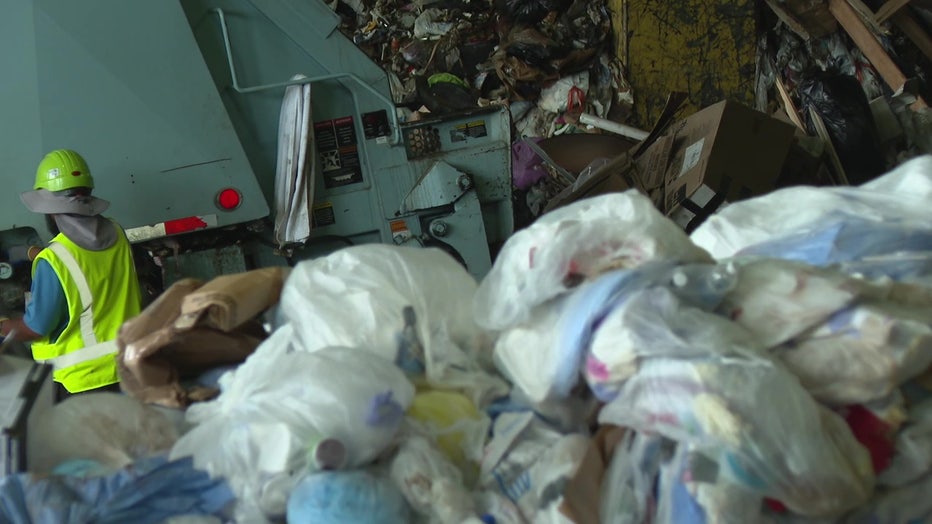 An employee sorts through trash at a Pinellas County landfill.