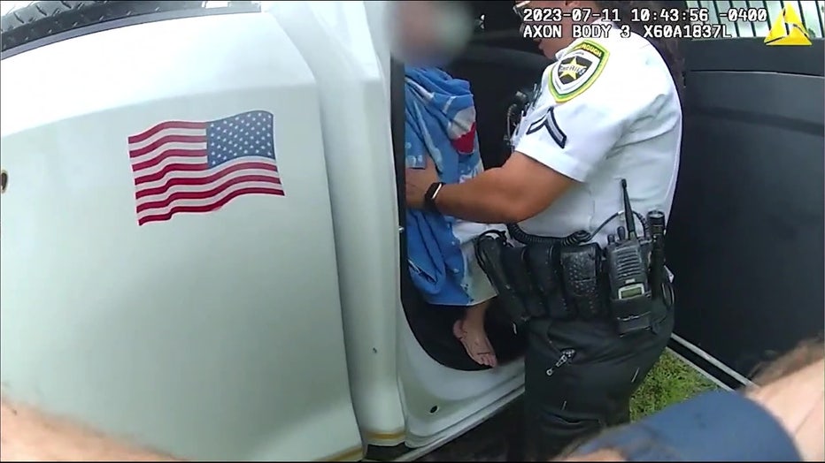 A deputies dries off the child after he was rescued from the pond. Image is courtesy of the Hillsborough County Sheriff's Office.