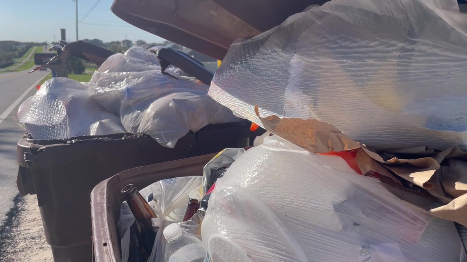 File: Trash piled up in a Polk County garbage can.