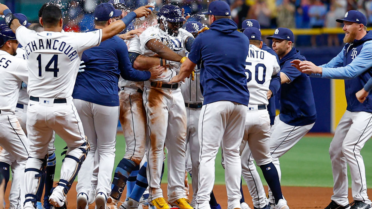 Tampa Bay Rays' Randy Arozarena is congratulated by teammates after scoring  the in the ninth inning of a baseball game against the Cleveland Indians,  Friday, July 23, 2021, in Cleveland. (AP Photo/Tony