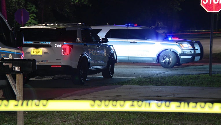 Police vehicles and crime scene tape at the scene of a shooting in Tampa.